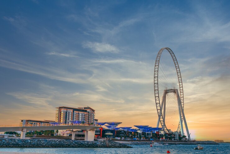 low-angle-shot-modern-design-building-with-huge-ferris-wheel-bluewaters-island-dubai_181624-25722