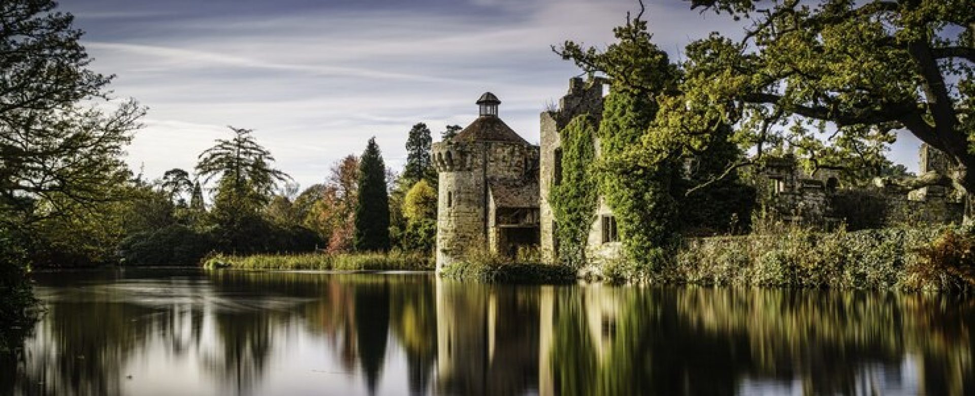 beautiful-scenery-castle-reflecting-clear-lake-surrounded-by-different-kinds-plants_181624-4277