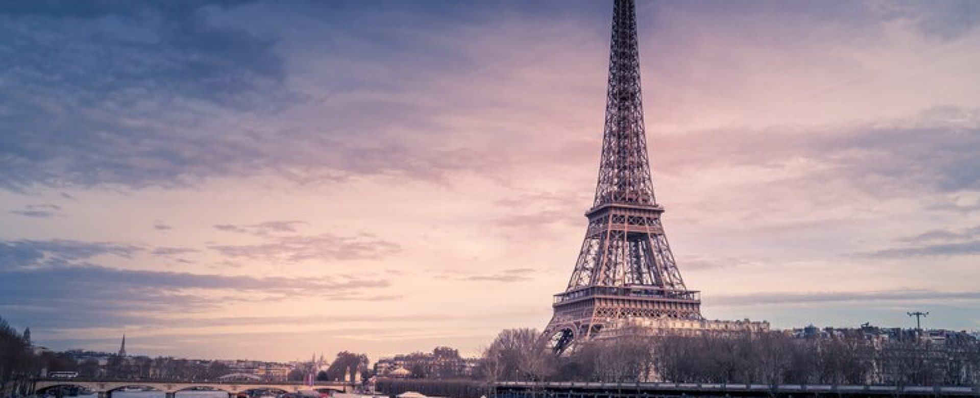 beautiful-wide-shot-eiffel-tower-paris-surrounded-by-water-with-ships-colorful-sky_181624-5118