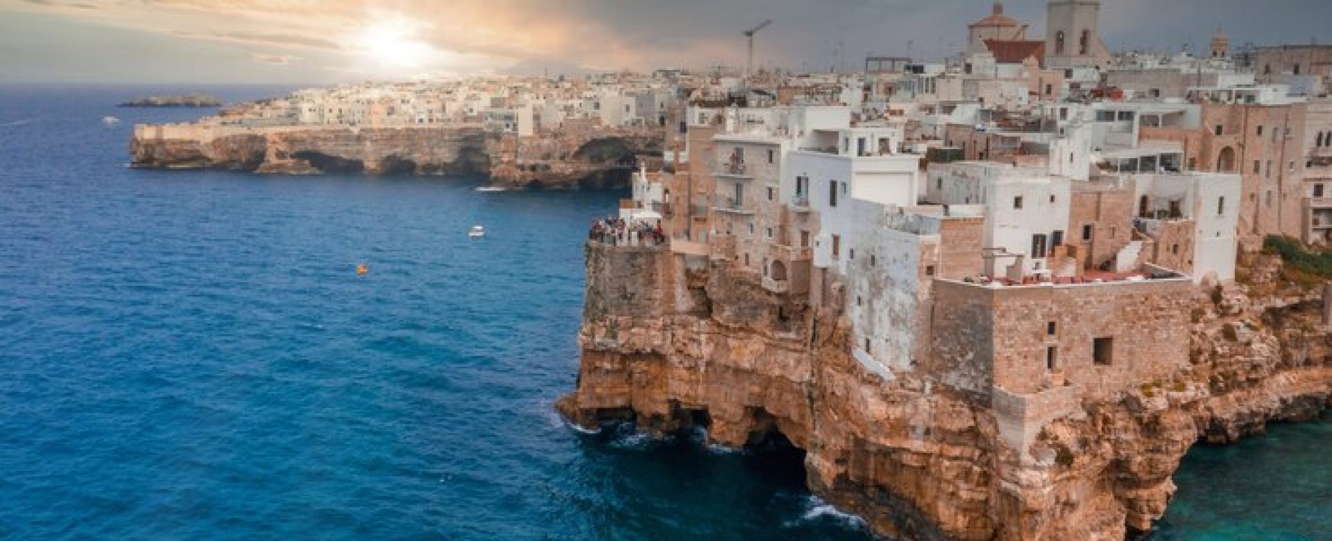 cityscape-polignano-mare-surrounded-by-sea-sunlight-cloudy-sky-italy_181624-42850