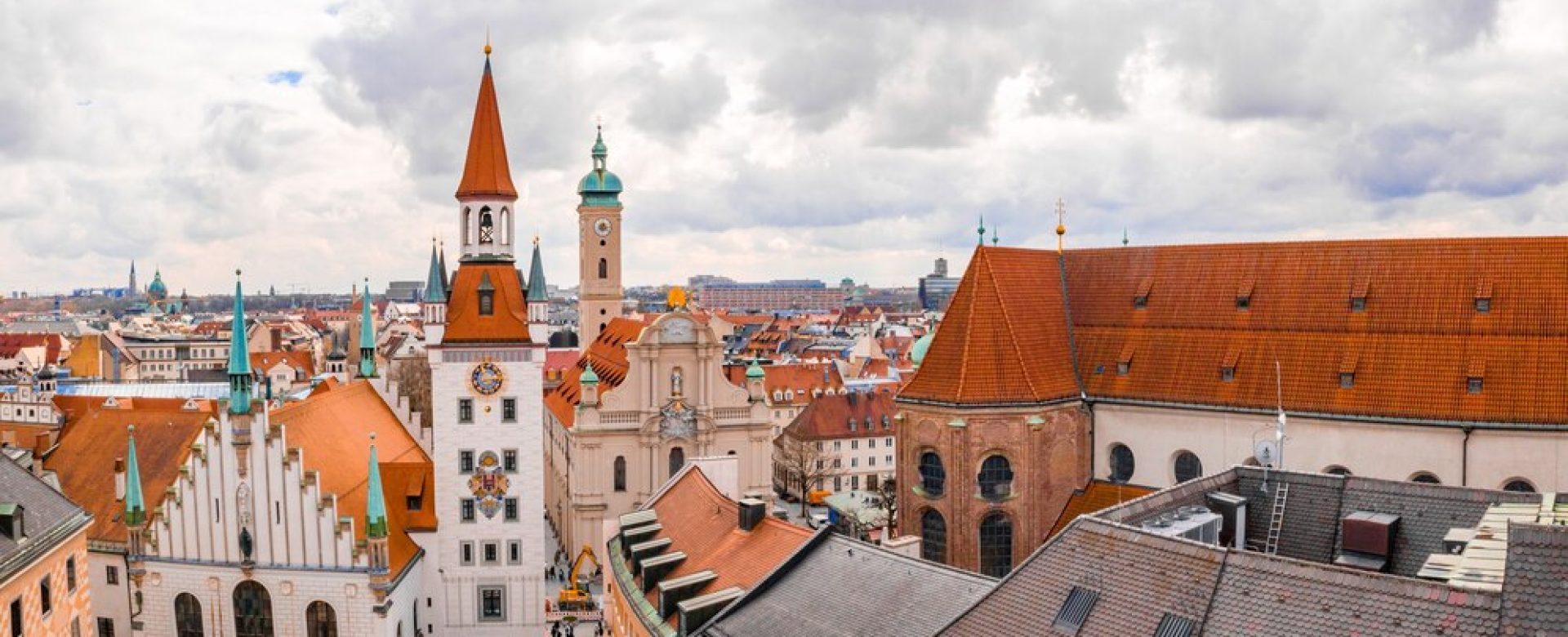 old-town-hall-surrounded-by-buildings-cloudy-sky-daytime-munich-germany_181624-38354